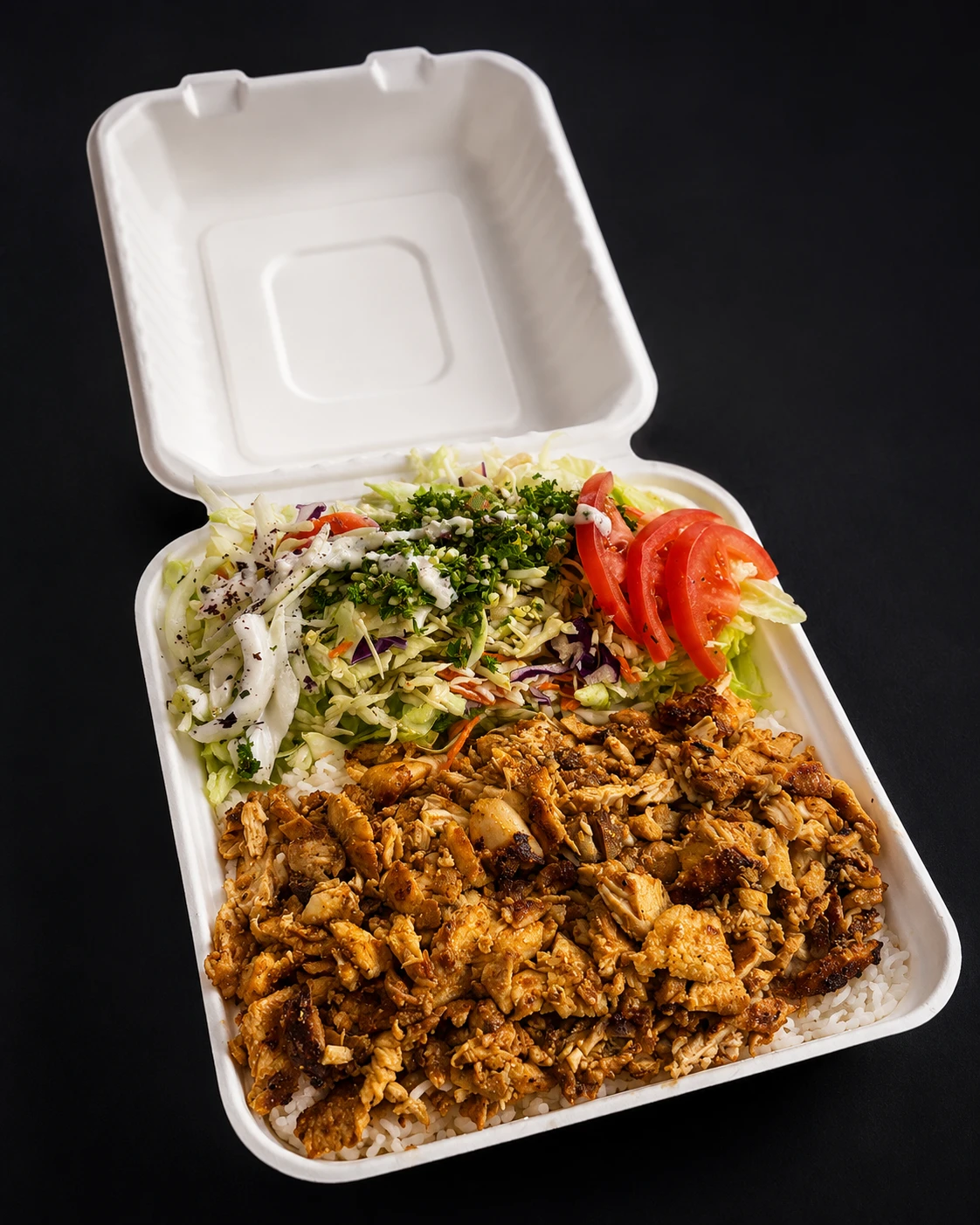 A generous rice platter with roasted meat, fresh lemon, and side sauces